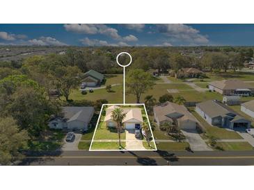 This aerial view showcases the property's layout, mature trees, and a well-maintained lawn at 1716 Terry Ne Cir, Winter Haven, FL 33881