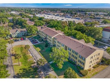 Spacious yellow apartment complex surrounded by lush green trees and a large parking area at 2047 Dixie Belle Dr # 2047K, Orlando, FL 32812