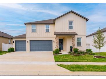 Beautiful two-story home with a two-car garage, a well-manicured lawn, and lovely landscaping at 2273 Lost Horizon Way, Clermont, FL 34715