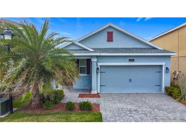 Charming single-story home featuring a well-manicured lawn, paved driveway, and attached two-car garage at 3088 Prelude Ln, Kissimmee, FL 34746