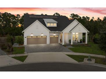 Beautiful modern farmhouse with a three-car garage and covered porch on a landscaped lawn at 3135 Vanguard Ct, St Cloud, FL 34771