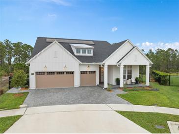 Beautiful, modern farmhouse-style home with a three-car garage and well-manicured lawn at 3135 Vanguard Ct, St Cloud, FL 34771