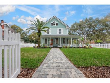 Charming two-story home featuring a welcoming front porch, manicured lawn, and classic architectural details at 415 W Rich Ave, Deland, FL 32720