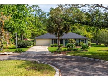 Charming single-story home with a well-manicured lawn, mature trees, and a winding driveway at 113 Wheatland Ct, Longwood, FL 32779