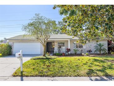 Charming single story home with white brick, an attached garage, front yard, and welcoming rocking chairs on the porch at 116 Cambridge Dr, Longwood, FL 32779