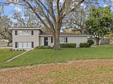 Charming two-story home featuring a well-manicured front yard and mature trees at 1228 Walker S Cir, Lakeland, FL 33805