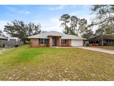 Charming single-story brick home featuring a well-maintained lawn and attached garage at 1600 Amboy Dr, Deltona, FL 32738