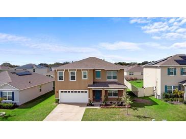 Two-story home featuring a manicured lawn, attached garage, and modern architectural details at 2024 Griffin Oaks Way, Tavares, FL 32778