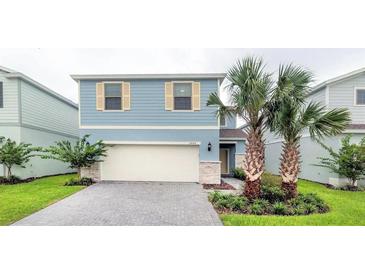 Charming two-story blue home with well-manicured landscaping and a two-car garage at 2486 Dubai St, Kissimmee, FL 34747