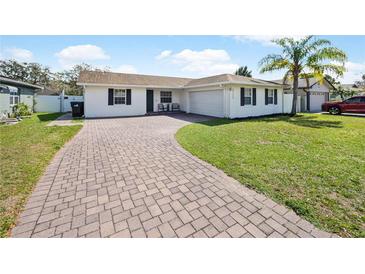 This home has a brick driveway, an attached garage, and a well manicured lawn with room to play at 3117 Shady Pine Ave, Winter Park, FL 32792