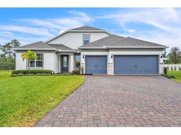 Charming two-story home with a brick driveway and a manicured front lawn at 6105 Citrus Grove Ct, St Cloud, FL 34771
