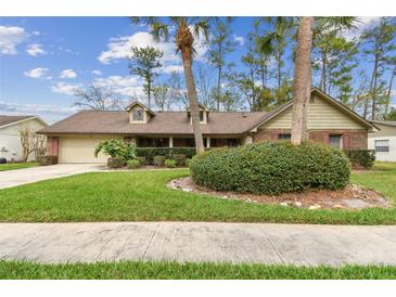 Charming single-story home featuring a well-manicured front yard, mature trees, and an attached two-car garage at 743 Riverbend Blvd, Longwood, FL 32779