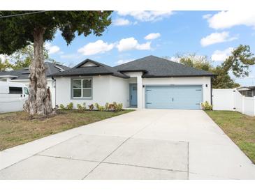 Charming home with a well-manicured lawn, blue garage door, and ample driveway space at 7633 Marietta St, Orlando, FL 32807