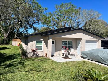 Charming single-story home features a well-manicured lawn, inviting patio set, and a convenient attached garage at 1218 Depugh St, Altamonte Springs, FL 32701