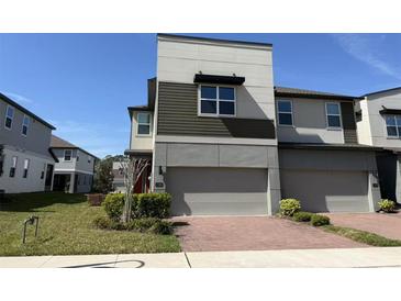 Modern two-story townhome featuring a two-car garage and a well-maintained front yard with green landscaping at 1522 Bantam Way, Winter Park, FL 32792