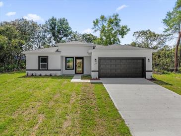 Charming single-story home with a well-maintained lawn and a two-car garage at 2483 Sw 163Rd Pl, Ocala, FL 34473