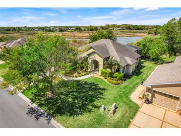 Beautiful home showcasing lush landscaping, backyard pond, and inviting curb appeal at 27127 Stoney Brook Dr, Leesburg, FL 34748