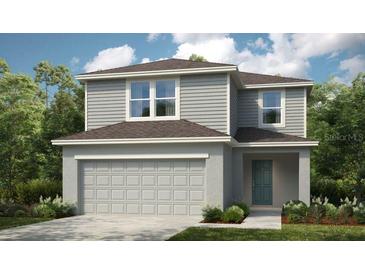 Charming two-story home with gray siding, covered entry, and attached two-car garage at 5169 Forget Me Not Ave, Lake Hamilton, FL 33851