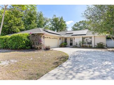 Inviting single-story home featuring a well-manicured lawn, a two-car garage, and a welcoming front entrance at 5267 Crisfield Ct, Orlando, FL 32808