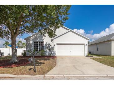 Charming single-story home features a well-manicured lawn, a two-car garage, and a classic, inviting facade at 547 Madina Cir, Davenport, FL 33837