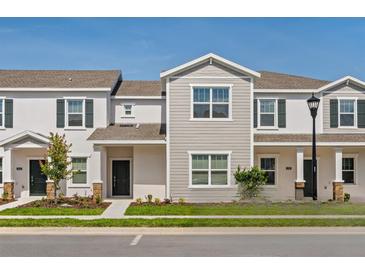 Charming townhome featuring a well-manicured lawn and tasteful exterior color scheme at 6068 Peaceful Pkwy, Clermont, FL 34714