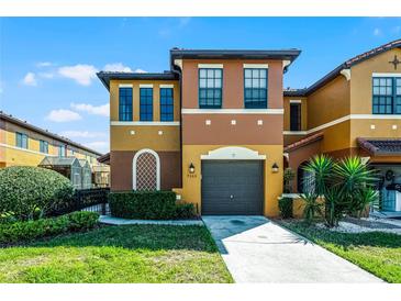 Inviting two-story home featuring a gray two-car garage, colorful stucco facade, and well-maintained landscaping at 9568 Muse Pl, Orlando, FL 32829