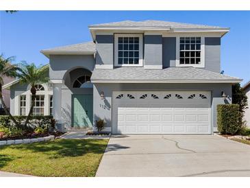 Charming two-story home with a well-maintained lawn and a two-car garage at 112 Tate Ct, Orlando, FL 32828