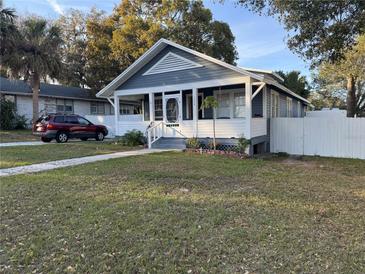 Charming bungalow with welcoming front porch, gray and white paint, and a well-maintained lawn at 1404 High St, Leesburg, FL 34748