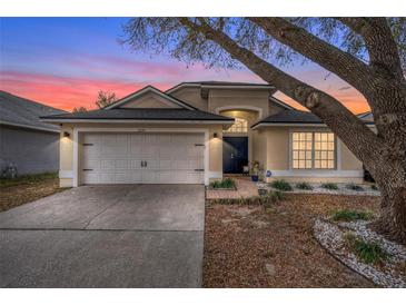 Charming single-story home with a two-car garage, manicured landscaping and lovely curb appeal at sunset at 2234 Rockwood Dr, Apopka, FL 32703