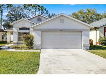 Charming single-Gathering home featuring a two-car garage and well-maintained front lawn and landscaping at 2978 Stillwater Dr, Kissimmee, FL 34743