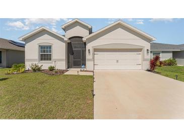 Charming single Gathering home showcasing a well-manicured lawn and a two-car garage at 4115 Ruby Run, Haines City, FL 33844