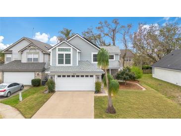 Charming two-story home featuring a well-manicured lawn and attached two-car garage at 5276 Rocking Horse Pl, Oviedo, FL 32765