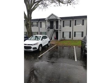 Two-story apartment building with black shutters, stairway to entry, and nearby parking at 7630 Forest City Rd # 059 Aka G, Orlando, FL 32810