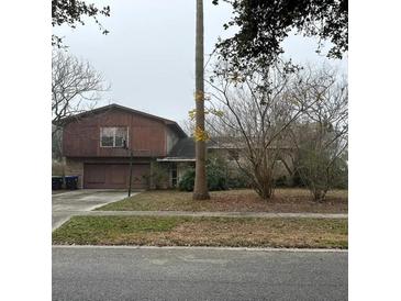 Charming two-story home with a two-car garage and basketball hoop on a tree-lined street at 8203 Bluestar Cir, Orlando, FL 32819