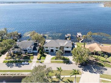 Breathtaking aerial view of a lakeside home with a private dock and lush landscaping at 9138 Bay Point Dr, Orlando, FL 32819