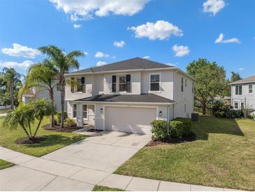 Charming two-story home featuring an attached two-car garage and a well-maintained lawn with tropical landscaping at 12621 Oulton Cir, Orlando, FL 32832