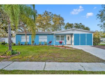 Charming single-story blue home with a well-maintained lawn and vibrant landscaping at 1416 E 20Th St, Sanford, FL 32771