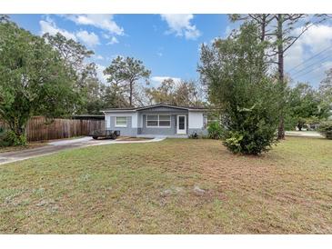 Charming single-story home featuring a spacious front yard, gray exterior, and covered carport at 200 Avenue C, Chuluota, FL 32766