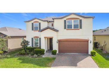 Charming two-story home featuring a well-manicured lawn, complemented by a two-car garage and a welcoming front entrance at 5311 Brydon Woods Cir, St Cloud, FL 34771