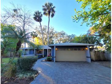 Charming single-story home featuring a two-car garage, blue facade, and meticulous landscaping at 621 Daron Ct, Winter Springs, FL 32708