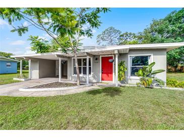 Charming single-story home with a covered carport, lush lawn, and a bright red front door at 704 Baywood Dr, Sanford, FL 32773