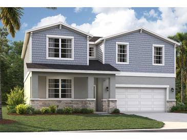 Charming two-story home featuring stone accents, shaker siding, a covered entry, and an attached two-car garage at 1136 Clay Blvd, Tavares, FL 32778