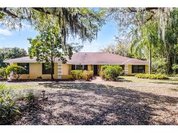 Charming single-story yellow brick home with lush landscaping and inviting curb appeal at 12002 Mckinnon Rd, Windermere, FL 34786