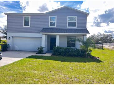 Charming two-story home with a well-manicured lawn and attached two car garage at 137 Willow Dr, Kissimmee, FL 34759