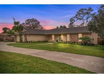 Charming one-story home featuring a large front yard, mature landscaping, and a brick and stucco exterior at 1581 Monica Joy Cir, Longwood, FL 32779
