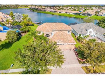 Stunning aerial view of a waterfront home with a tile roof and lush landscaping at 2631 Captains Ct, Kissimmee, FL 34746