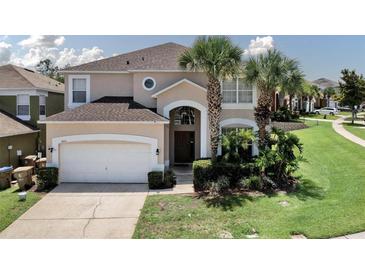 Inviting two-story home with manicured lawn, arched entryway, and a two car garage at 2801 Lido Key Ct, Kissimmee, FL 34747