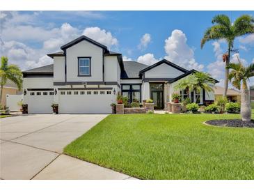 Stunning two-story home featuring a three-car garage, lush landscaping, and a well-manicured lawn at 3180 Pawleys N Loop, St Cloud, FL 34769