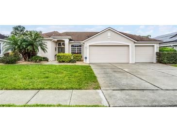 Charming single-story home with a well-manicured lawn, two-car garage, and beautifully landscaped front yard at 335 Prestwick Dr, Davenport, FL 33897