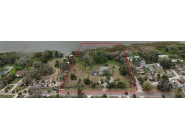 Large waterfront property with red boundary lines, lush greenery, and dock access showcasing prime real estate potential at 3540 Walker Rd, Apopka, FL 32703
